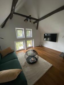 a living room with a couch and a tv at Scheunentraum Brenig in Bornheim