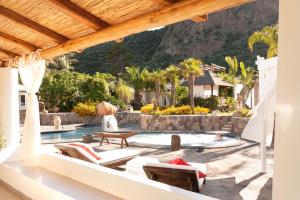 eine Terrasse mit Pool und ein Haus in der Unterkunft Hotel Oasi in Panarea