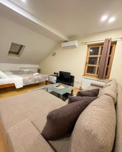 salon z kanapą i łóżkiem w obiekcie Sarajevo Apartments Casa United w Sarajewie