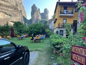 a car parked in front of a restaurant with mountains in the background at Archontiko Mesohori Meteora in Kalabaka