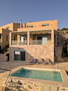 a villa with a swimming pool in front of a house at Ouzo Panoramic Houses 1, with private pool in Plomari