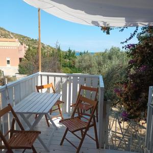 einen Tisch und Stühle auf einer Veranda mit Meerblick in der Unterkunft Katelios Farm House Loft in Kateliós
