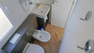a small bathroom with a sink and a toilet at Portofelice Camping Village in Eraclea Mare