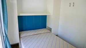 um pequeno quarto com uma pequena cama num quarto em Portofelice Camping Village em Eraclea Mare