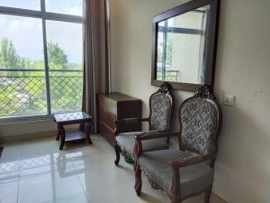a living room with two chairs and a mirror at Bhurban Continental Apartment 45-F in Bhurban