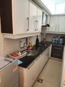 a kitchen with white cabinets and a sink at Bhurban Continental Apartment 45-F in Bhurban