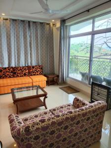 ein Wohnzimmer mit einem Sofa und einem Tisch in der Unterkunft Bhurban Continental Apartment 45-F in Bhurban