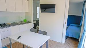 a small kitchen with a white table and a blue bed at Portofelice Camping Village in Eraclea Mare