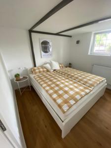 a large bed in a white room with a window at Scheunentraum Brenig in Bornheim