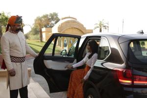 Un homme et une femme quittant une voiture dans l'établissement Jaisalmer Marriott Resort & Spa, à Jaisalmer