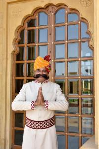 a man wearing an orange hat and a bow tie at Jaisalmer Marriott Resort & Spa in Jaisalmer