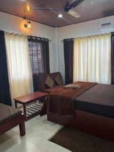 a bedroom with a bed and a table and a couch at J.J Bed and Breakfast in Port Blair