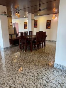 a dining room with a table and chairs on a stone floor at J.J Bed and Breakfast in Port Blair