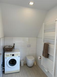 a bathroom with a washing machine and a toilet at Refugium in Nortrup in Nortrup
