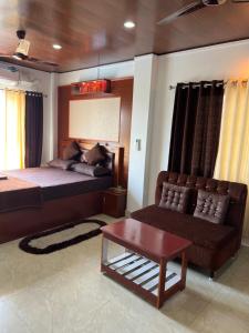 a bedroom with a bed and a couch and a chair at J.J Bed and Breakfast in Port Blair