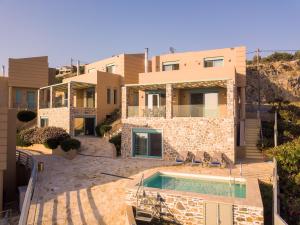 a house with a swimming pool in front of it at Ouzo Panoramic Houses 2, with private pool in Plomarion