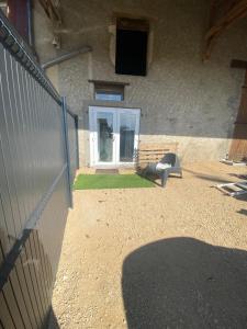 a door of a building with a fence and grass at « Le Petit Louis » in Briord