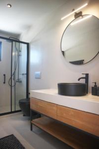 a bathroom with a sink and a mirror at Heterotopia Villas in Chortáta