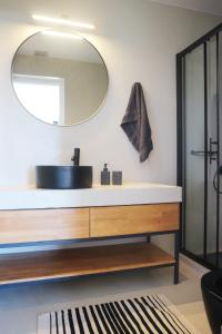 a bathroom with a sink and a mirror at Heterotopia Villas in Chortáta