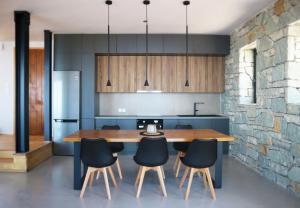 a kitchen with a wooden table and some chairs at Heterotopia Villas in Chortáta