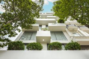 un bâtiment blanc avec des plantes sur son côté dans l'établissement LP rental - Minimalist Studio Apartments, à Thu Dau Mot