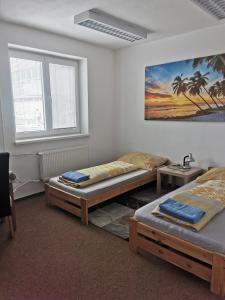 a room with two beds and a painting on the wall at Living Bratislava & Bus Station & Mlynské Nivy in Bratislava