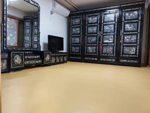 an empty room with a mirror and a tv at Authentic Leedo Hanok in Seoul