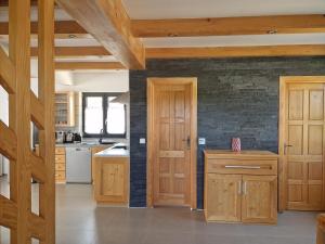 a kitchen with wooden cabinets and a brick wall at Plitvice Apis in Korenica