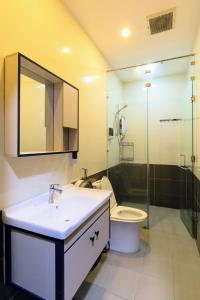 uma casa de banho com um lavatório, um WC e um espelho. em Base Backpackers em Cidade de Ho Chi Minh