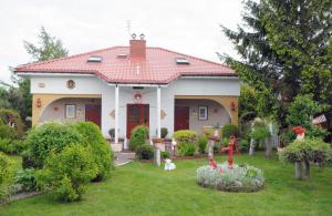 a house with a yard with flowers in front of it at Cztery Pory Roku in Grzybowo