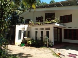 een wit huis met een balkon erop bij San villa in Sulutanagoda