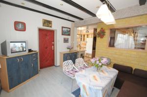 a living room with a table and a red door at Cztery Pory Roku in Grzybowo