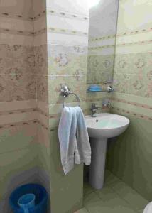 a bathroom with a sink and a white towel at Bhurban Continental Apartment 45-F in Bhurban