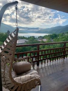 a swinging chair sitting on a porch with a view at Panorama ananuri guest house in Ananuri