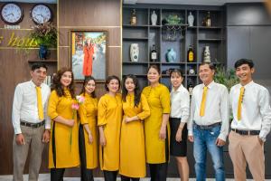 a group of people in yellow uniforms posing for a picture at Hannah House Hoi An in Hoi An