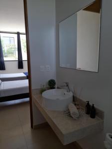 y baño con lavabo blanco y espejo. en Paraíso Casa Turquesa Playa del Carmen en Playa del Carmen
