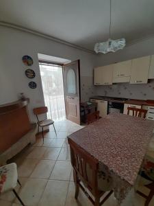 a kitchen with a table and a dining room with a table and chairs at Gabriella in SantʼEufemia a Maiella