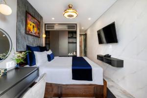a hotel room with a bed and a television at Hannah House Hoi An in Hoi An