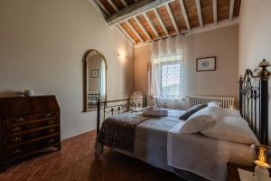 Schlafzimmer mit einem Bett, einer Kommode und einem Spiegel in der Unterkunft Masseria Del Bosco - Podere Palazzone in Chianciano Terme
