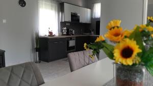 uma cozinha com uma mesa com um vaso de girassóis em Jenny vendégház em Zalakaros