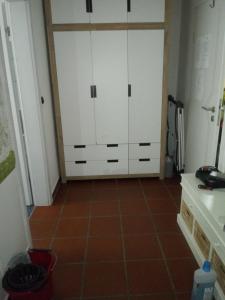 a kitchen with white cabinets and a tile floor at Oppidum Brilon in Brilon