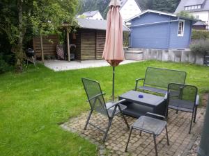 a patio with a table and an umbrella and chairs at Oppidum Brilon in Brilon