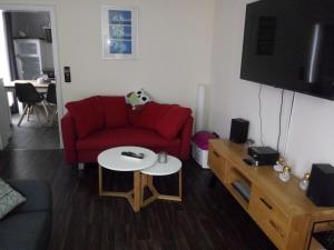 a living room with a red couch and a table at Oppidum Brilon in Brilon