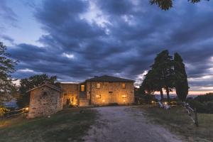een groot stenen gebouw op een onverharde weg 's nachts bij Masseria Del Bosco - Podere Palazzone in Chianciano Terme