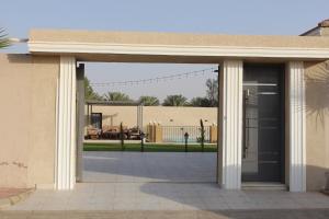 ein Gebäude mit einer großen Glastür und einer Terrasse in der Unterkunft شاليه سبع نجوم in Al Bukayriyah