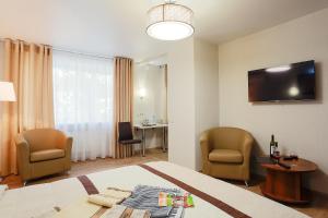 a hotel room with a bed and two chairs and a table at APART-HOTEL VEGUS in Uralsk