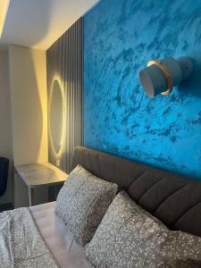 a bedroom with a bed with a blue wall at Square Vanilla Boutique Apart-Hotel in Skopje +90 photos