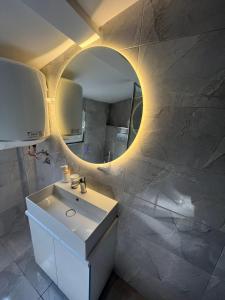 La salle de bains est pourvue d'un lavabo blanc et d'un miroir. dans l'établissement Square Vanilla Boutique Apart-Hotel, à Skopje
