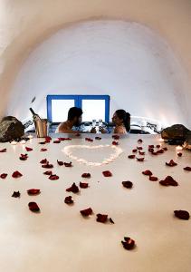 a group of roses sitting on a table at Rafael' s Mediteranian Cave Suites in Firostefani