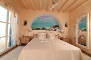 une chambre avec un grand lit avec une grande fenêtre dans l'établissement La Vie In Blue, à Ornos 32 autres photos